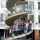 Young adults stand smiling on a spiral staircase