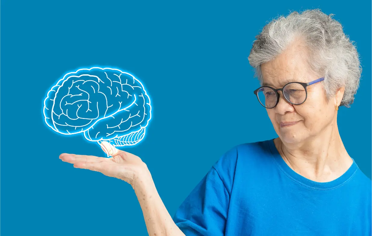 Older woman holds image of a brain in her hand to represent Alzheimer's Disease