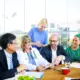 Group of various healthcare professionals gathers at meeting around a table in a hospital.
