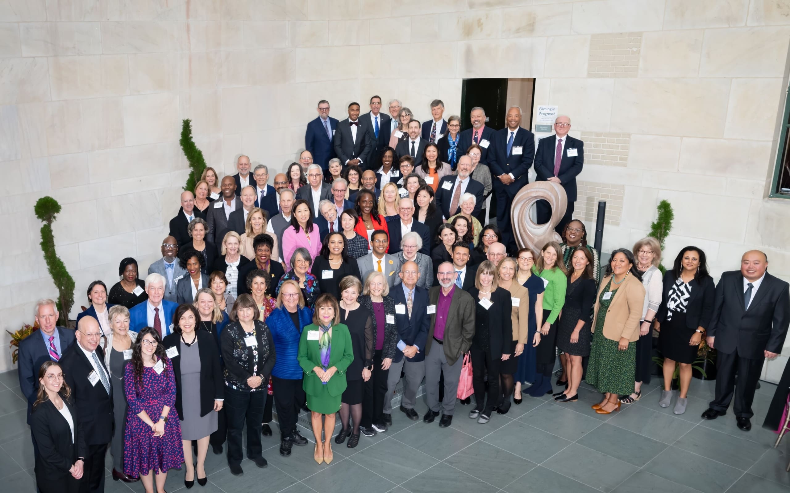 Large crowd of people gathered together in large room with marble walls.