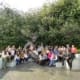 Group of 30 smiling people gathered in front of a large statue of Albert Einstein.